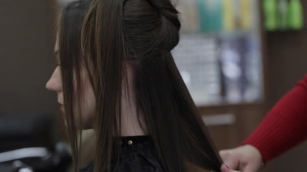 Frisören göra ett hår polering hennes medelålders kvinnlig kund. — Stockvideo