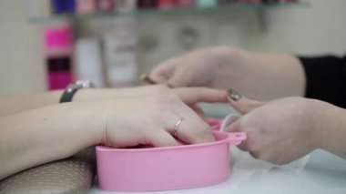Kadın onun manikür için boyalı tırnakları Başlarken önce temizlenmiş tırnaklarını alır