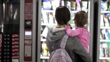 Anne ve kızı bir çerez Otomatı Havaalanı içinde seçme