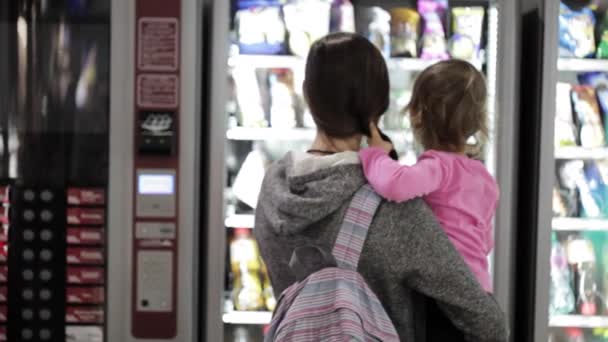 Matka a dcera výběrem občerstvení na automat uvnitř letiště — Stock video