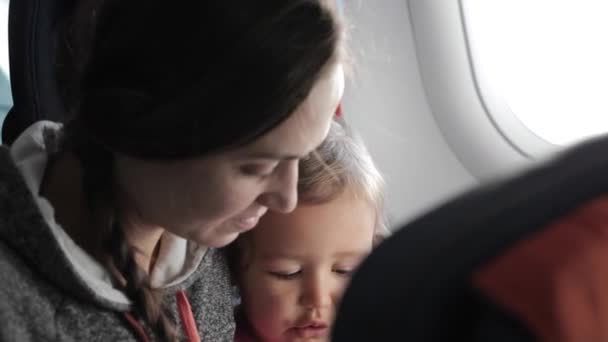 Küçük kızı uçağa yolculuk ile genç çekici kadın. — Stok video