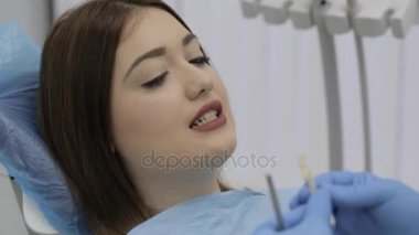 Diş hekimi kontrol ve genç bayan hasta diş rengini seçin.