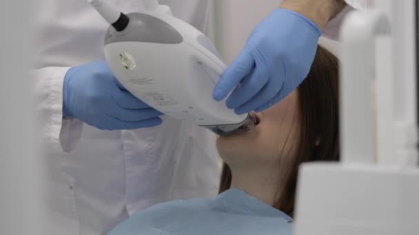 Arts een mooie jonge vrouw voor laser whitening tanden procedure voorbereiding. — Stockvideo