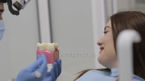Dentista che parla con il paziente e mostra un modello di denti . — Video Stock