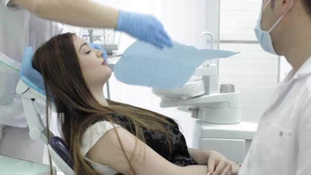 El médico y la enfermera están preparando al paciente para un procedimiento en el consultorio dental — Vídeo de stock