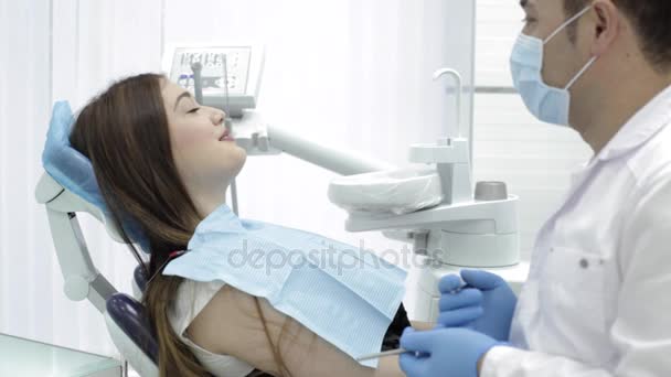 Tandheelkunde. De arts praat met een patiënt iets grappig en patiënt lacht. — Stockvideo