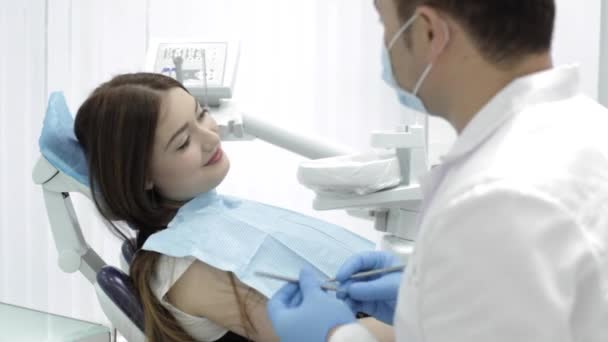 Odontología. El médico habla con un paciente algo divertido y el paciente sonríe . — Vídeos de Stock