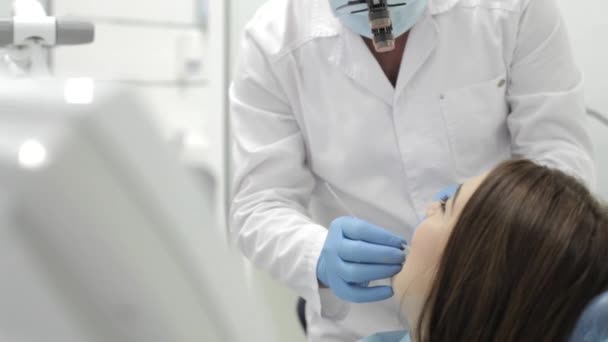 O dentista faz o procedimento. Beutyful jovem visita uma clínica odontológica moderna . — Vídeo de Stock