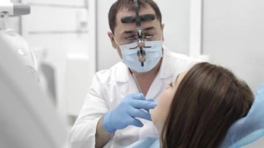 Diş hekimi yordam bulunur. Beutyful genç kadın modern bir diş kliniği ziyaret.