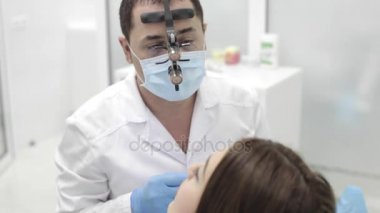 Diş hekimi yordam bulunur. Beutyful genç kadın modern bir diş kliniği ziyaret.