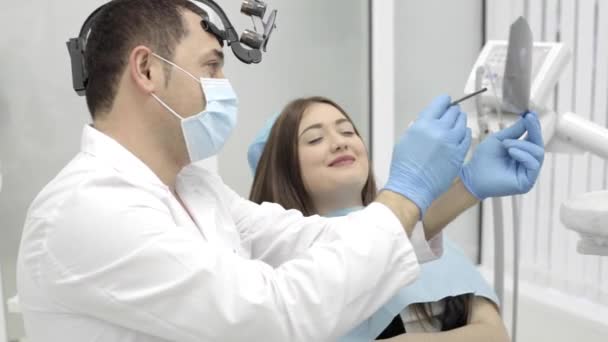 Dentysta pokazuje, że pacjent rentgenowskie zębów w gabinecie stomatologicznym — Wideo stockowe