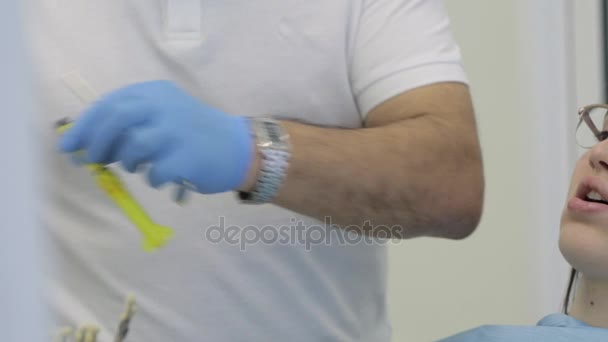 Medicul dentist de sex masculin face procedura pe pacientul tânăr de sex feminin la clinica modernă — Videoclip de stoc