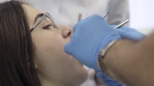 Лікар і медсестри починають стоматологічну процедуру з молодою пацієнткою . — стокове відео