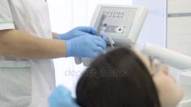 Doktor ve nurs olan genç kadın hastaya bir diş prosedür başlar.