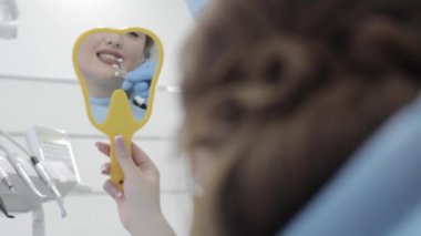 Kadın ziyaret diş Kliniği. Diş hekimi kontrol ve diş rengini seçin.