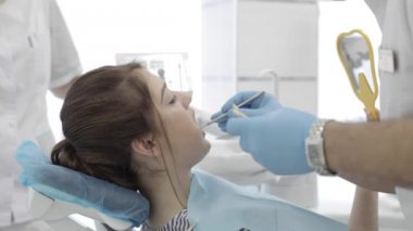 Kadın ziyaret diş Kliniği. Diş hekimi kontrol ve diş rengini seçin.