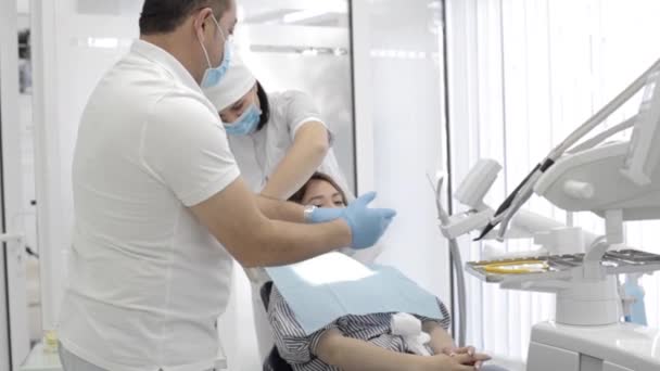 Dokter en verpleegster voorbereiding van een patiënt voor tandheelkundige examen. — Stockvideo