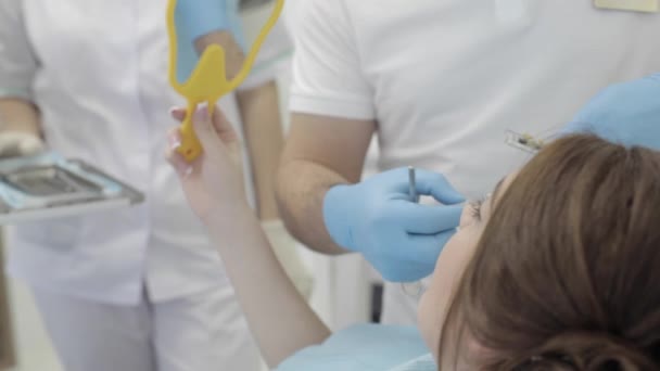 Kadın ziyaret diş Kliniği. Diş hekimi kontrol ve diş rengini seçin. — Stok video