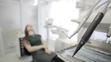 Dişçi koltuğu arka planda üzerinde diş ekipman ve Bayan hasta taşındı