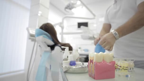 Крупним планом стоматолог одягає рукавички в сучасну стоматологічну клініку . — стокове відео
