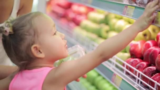 Mujer y niña eligiendo frutas durante las compras en el supermercado — Vídeo de stock