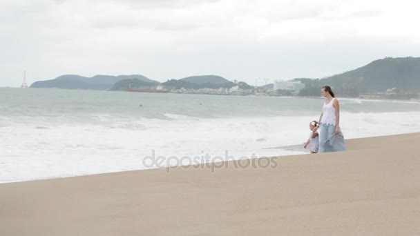 Mãe com filhinha andando ao longo do mar em mau tempo — Vídeo de Stock