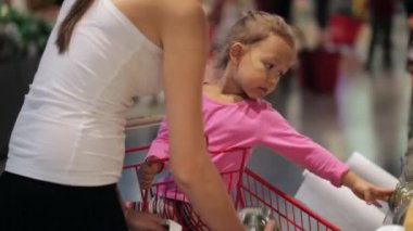 Arabası balkabağına süpermarkette seçme içinde küçük kızı ile genç anne