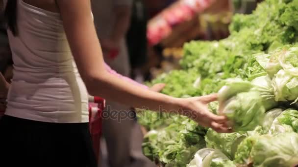 Anne ve küçük kızı süpermarkette sebze seçme genç ailesi. — Stok video