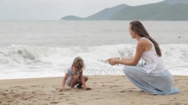 Küçük kızı kötü havada deniz boyunca yürüyüş ile anne