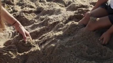 Anne ve kızı kum ile sahilde oynarken