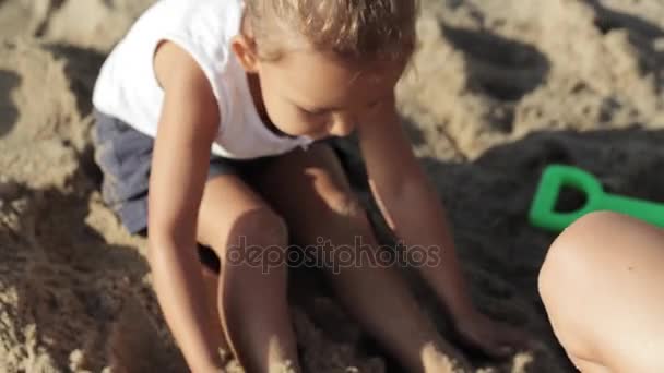 Anya és lánya játszik a homok a tengerparton — Stock videók