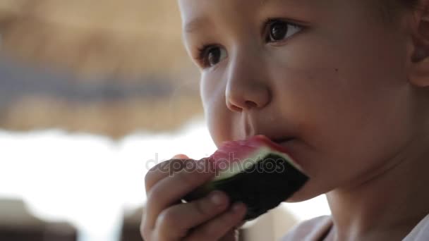 Primo piano di lttle cute bambina seduta sull'altalena e mangiare anguria rossa . — Video Stock