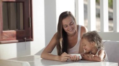 Anne ve kızı smartphone vasıl belgili tanımlık balkon komik video izlerken