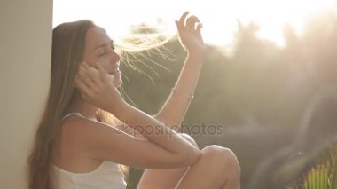 O telefonda konuşurken bir kadın üzerinde parlayan yaz güneş ışınlarının.