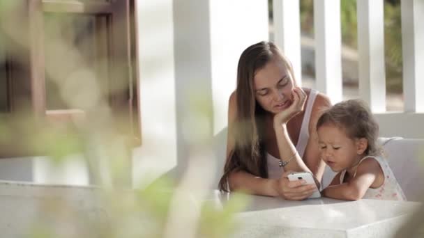 Mor och dotter titta rolig video på smartphone på balkongen — Stockvideo