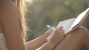 Balkon oturma ve Diary Bahçe ile arka plan üzerinde yazma kadın