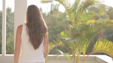 Terasa çıkıp ve kollarını germe genç çekici kadın