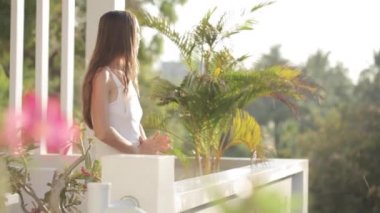 Terasa çıkıp ve kollarını germe genç çekici kadın