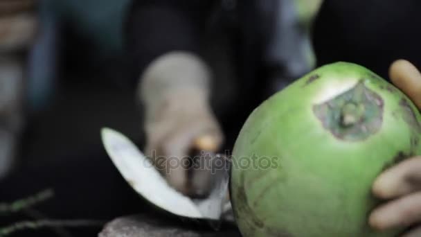 Вуличний продавець відкриває кокос з великим ножем . — стокове відео