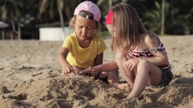 İki küçük sevimli kız sahilde kum ile oynamak