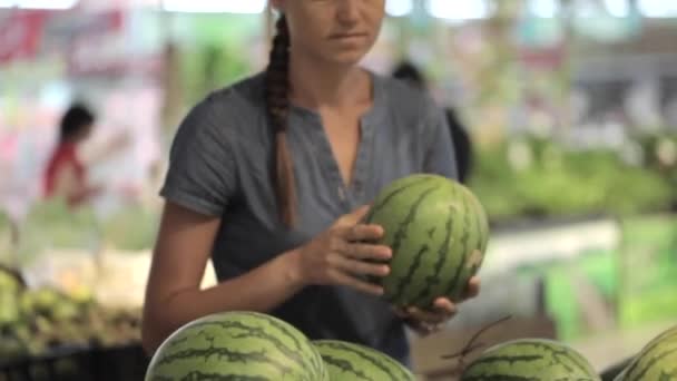 Giovane donna attraente in un supermercato seleziona la frutta e verdura . — Video Stock