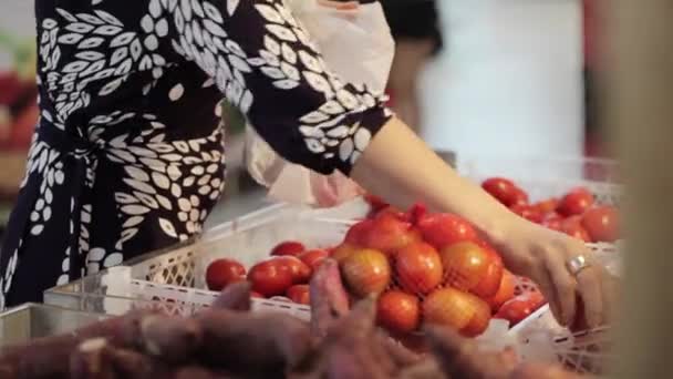 Mladá atraktivní žena v supermarketu vybere ovoce a zeleniny. — Stock video