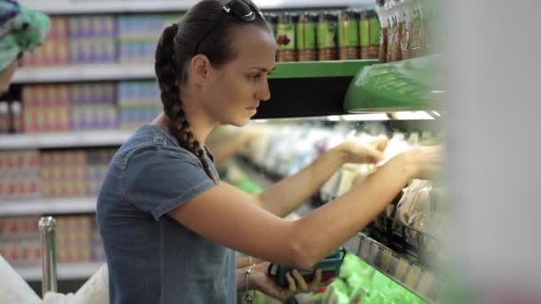 Dvě mladé atraktivní ženy výběr potravin v supermarketu — Stock video