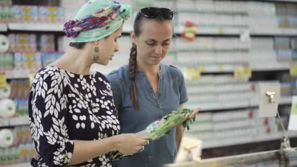 Duas amigas selecionando alface verde no supermercado — Vídeo de Stock
