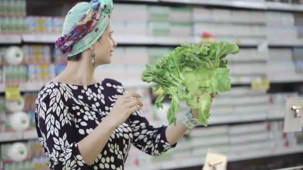 Two female friends selecting green lettuce in grocery store — Stock Video