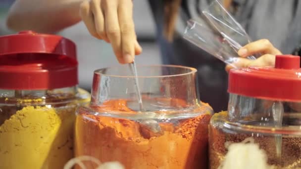 Femme achetant de la cannelle, du paprika et du curry en poudre dans un supermarché bio — Video