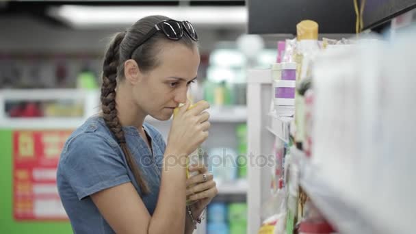 Dona de casa escolhendo produtos de cuidados com o corpo no supermercado . — Vídeo de Stock