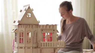 Genç kadın küçük kızı için oyuncak ev bina