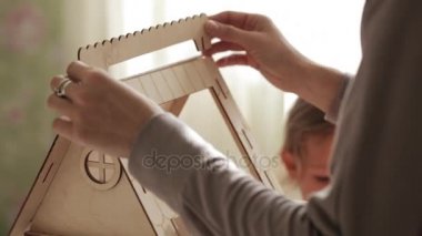 Genç kadın küçük kızı için oyuncak ev bina