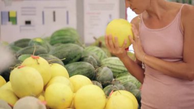 Genç kadın kavun süpermarkette seçme